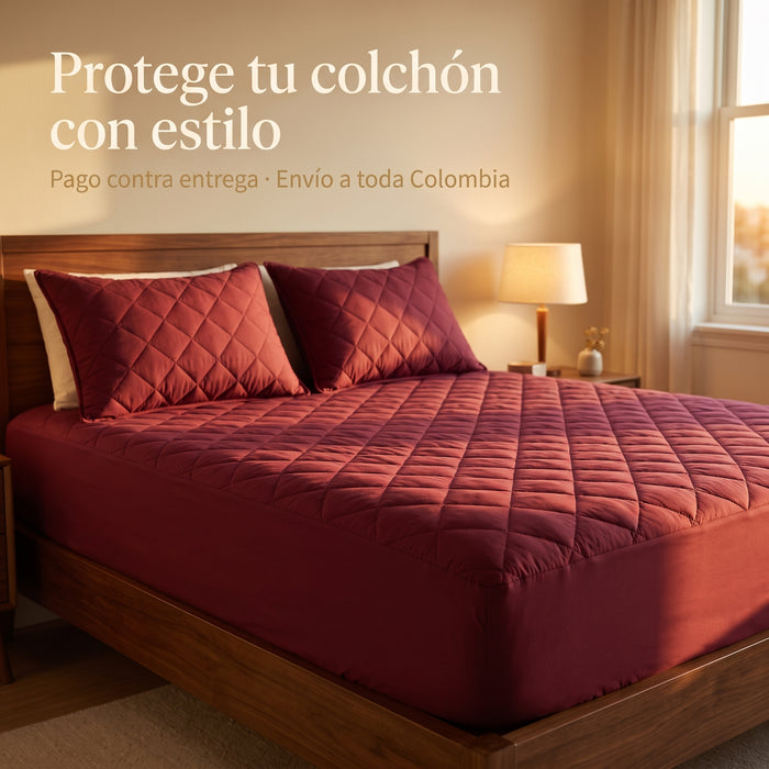 Protector de colchón acolchado vino tinto con 2 fundas a juego sobre cama de madera, luz cálida de atardecer