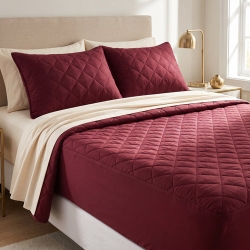 Cama vestida con protector de colchón acolchado vino tinto en rombos y fundas de almohada a juego